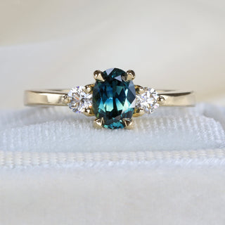 Three-stone engagement ring handmade by Lilia Nash in recycled gold, set with ethical diamonds and sapphires.