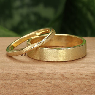 Handmade solid 9ct wedding bands - 2mm ribbon twist ring and 5mm wide flat profile band with signature spun silk texture.