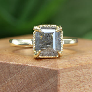 Close-up of 1.9ct rose cut salt and pepper diamond engagement ring on wooden surface.