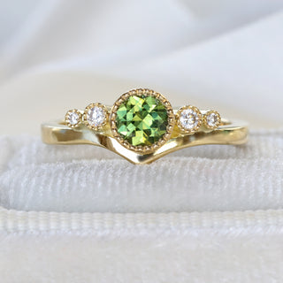 Close-up of fair trade green sapphire in milgrain bezel setting on handmade 18ct gold wishbone ring.