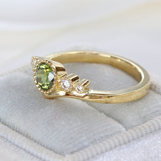 Handmade 18ct gold green sapphire and diamond wishbone engagement ring photographed at an angle.