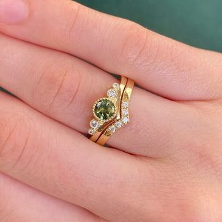 Green sapphire wishbone engagement ring in 18ct gold and matched diamond wisgbone wedding band, shown on hand.