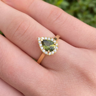 18ct gold green sapphire and diamond halo engagement ring shown worn on hand.