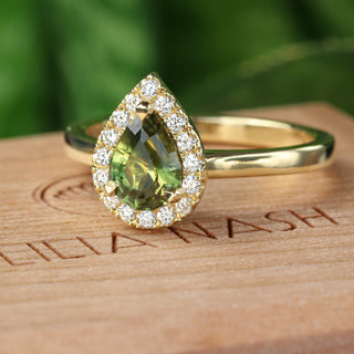 Side view of handmade 18ct gold green sapphire halo engagement ring.
