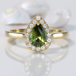 Pear cut green sapphire engagement ring with a halo of Canadian diamonds
