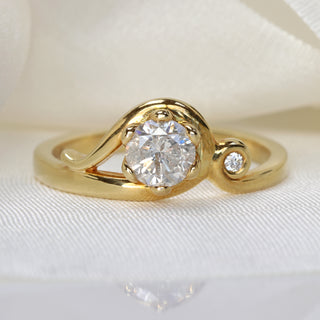 Handmade Art Nouveau icy diamond engagement ring in 18ct gold photographed on soft neutral background.