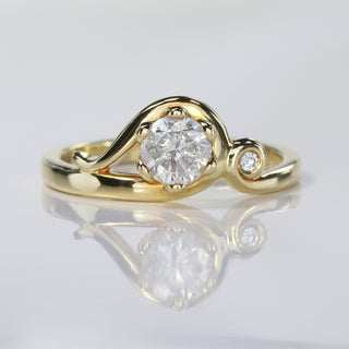 Handmade Art Nouveau 18ct gold engagement ring with icy diamond and small diamond accent on reflective surface.