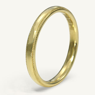 18ct gold 2.5mm wide court profile wedding band with hand engraved border