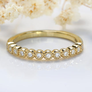 18ct gold diamond half eternity band on a white background with flowers
