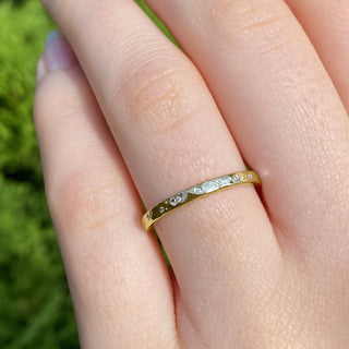 18ct gold slim hammered wedding band set with 20 diamonds worn on the hand