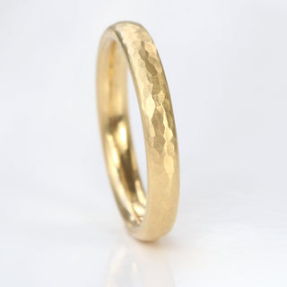 9ct gold 3mm court wedding band with hammered finish on a white surface