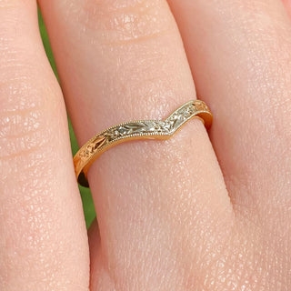 9ct gold wishbone wedding ring with orange blossom engraving worn on the hand.