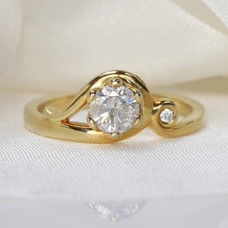 Handmade Art Nouveau icy diamond engagement ring in 18ct gold photographed on soft neutral background.