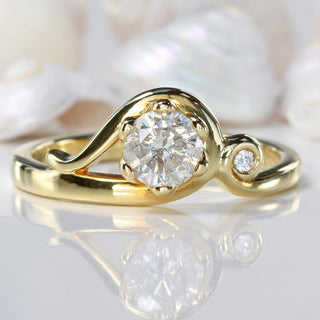 Lilia Nash Art Nouveau style 18ct gold ring set with a diamond. On grey background with seashells. 