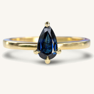 18ct gold solitaire engagement ring set with a pear cut blue sapphire