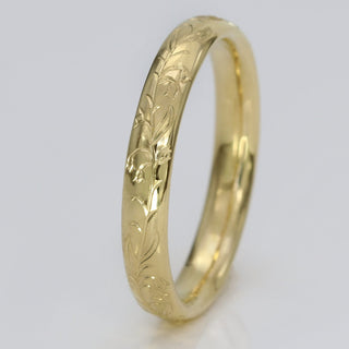Engraved Bluebells 18ct gold 3mm court wedding ring on white surface