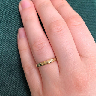 18ct gold 3mm court wedding ring with hand engraved bluebell flowers around the band. Shown worn on the hand