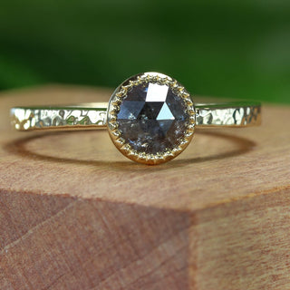 18ct gold salt and pepper diamond solitaire ring photographed outdoors on wooden surface.