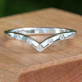 Custom made platinum diamond wishbone wedding ring on a wooden box