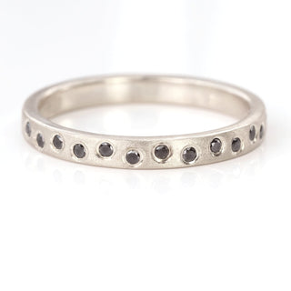 Custom 18ct white gold black diamond half eternity ring on a white surface