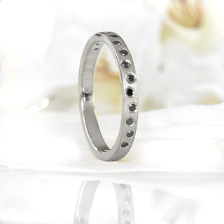 Custom 18ct white gold wedding band with black diamond on a white surface 