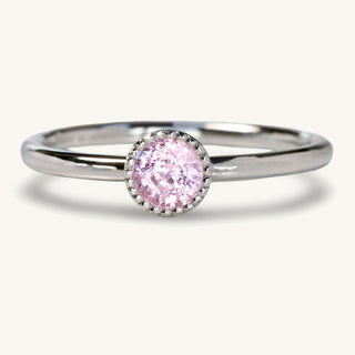 Handmade petite pink sapphire platinum solitaire engagement ring. The sapphire is held in a bezel setting with a milgrain border
