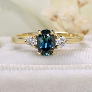 18ct gold Parti sapphire and diamond trilogy engagement ring styled with soft floral background.