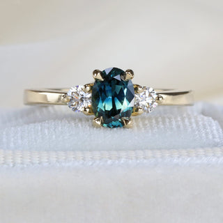 Close-up of handmade sapphire and diamond trilogy engagement ring, recycled gold band, ready to ship from Cornwall.