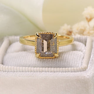 Handmade 18ct gold emerald cut salt and pepper diamond engagement ring on display stand.