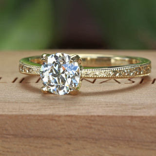 Angled view of 18ct gold hand engraved solitaire engagement ring set with a old European cut lab diamond - one carat in weight