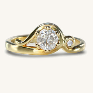 Handmade Art Nouveau 18ct gold engagement ring with icy diamond and small diamond accent on reflective surface.