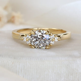 18ct gold cluster engagement ring with salt and pepper diamond photographed on pale felt ring box.