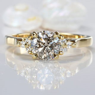 Salt and pepper diamond cluster 18ct gold engagement ring on reflective surface.