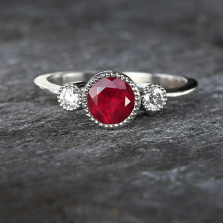 Ruby and diamond ring photographed on textured background