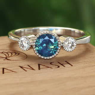 Platinum trilogy engagement ring with fair trade deep teal sapphire and diamonds