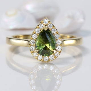 Pear cut green sapphire engagement ring with a halo of Canadian diamonds
