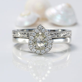 Pear cit diamond halo engagement ring with orange blossom engraved wedding band