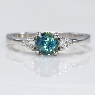 Platinum trilogy engagement ring with teal sapphire and two round diamonds 