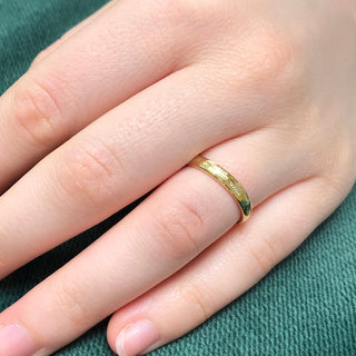18ct gold court wedding ring with hand engraved lavender flowers around the band.  Shown being worn on the finger