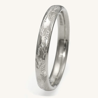 Platinum court wedding ring hand engraved with lavender flowers on a white surface
