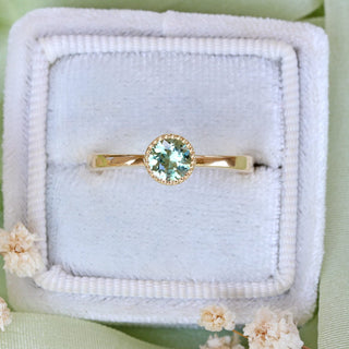 Green sapphire solitaire engagement ring in 18ct gold presented in a handmade wooden ring box.