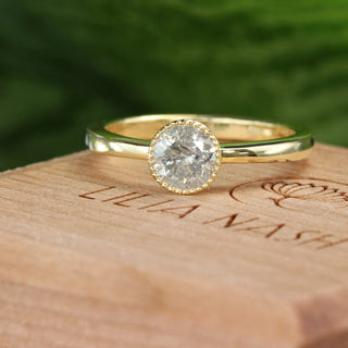 18ct gold salt and pepper diamond solitaire ring photographed on wooden surface.