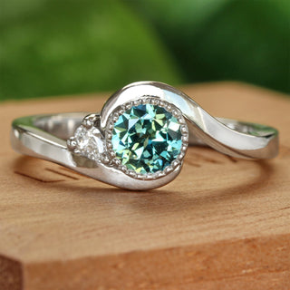 Platinum teal sapphire and diamond wave engagement ring, handmade by Lilia Nash