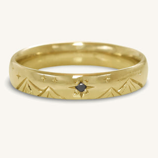 Handmade sustainable 18ct gold 4mm court wedding ring with engraved stars, mountains and a black diamond North Star.