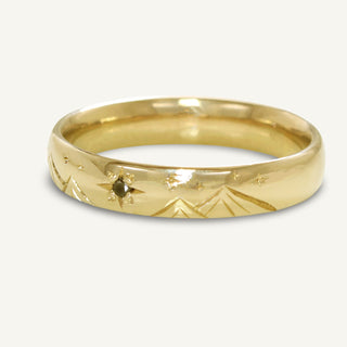 Side view of 4mm court men's wedding band with hand engraved stars and mountains. The largest star is set with a black diamond.
