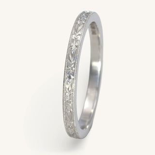 Handmade sustainable 950 platinum slim wedding band with hand engraved orange blossom pattern and milgrain border around the 2mm wide band