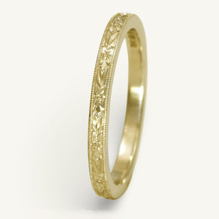 18ct gold slim wedding ring with orange blossom engraving, on a white background