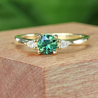 Dark green sapphire and diamond trilogy engagement ring in 18ct gold on a wooden box