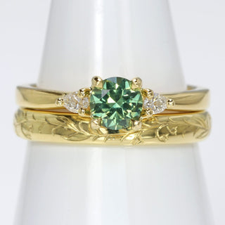 18ct gold green sapphire and diamond trilogy engagement ring with a bluebells hand engraved wedding band