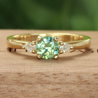 Green sapphire and pear cut diamond 18ct gold engagement ring  on wooden box